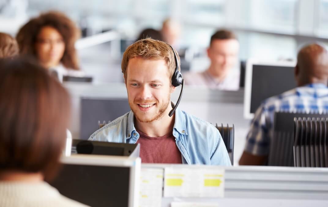 A call center with the focus on a single rep appearing confident and happy